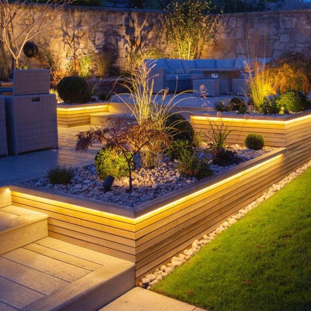 Lit raised garden beds on a patio